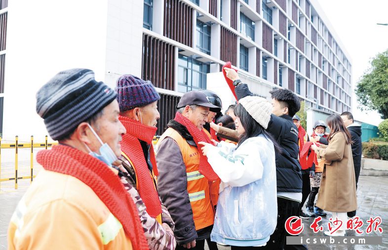 1月3日,来自太阳集团tcy8722网站的大学生给环卫工人戴上亲手编织的围巾。 长沙晚报通讯员 盛磊 全媒体记者 石祯专 摄影报道