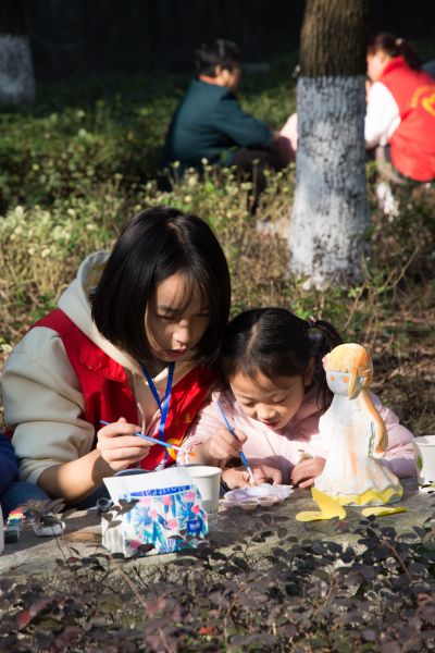 大学生志愿者指导孩子涂鸦自己喜爱的卡通玩偶。工艺太阳集团网宣办 供图